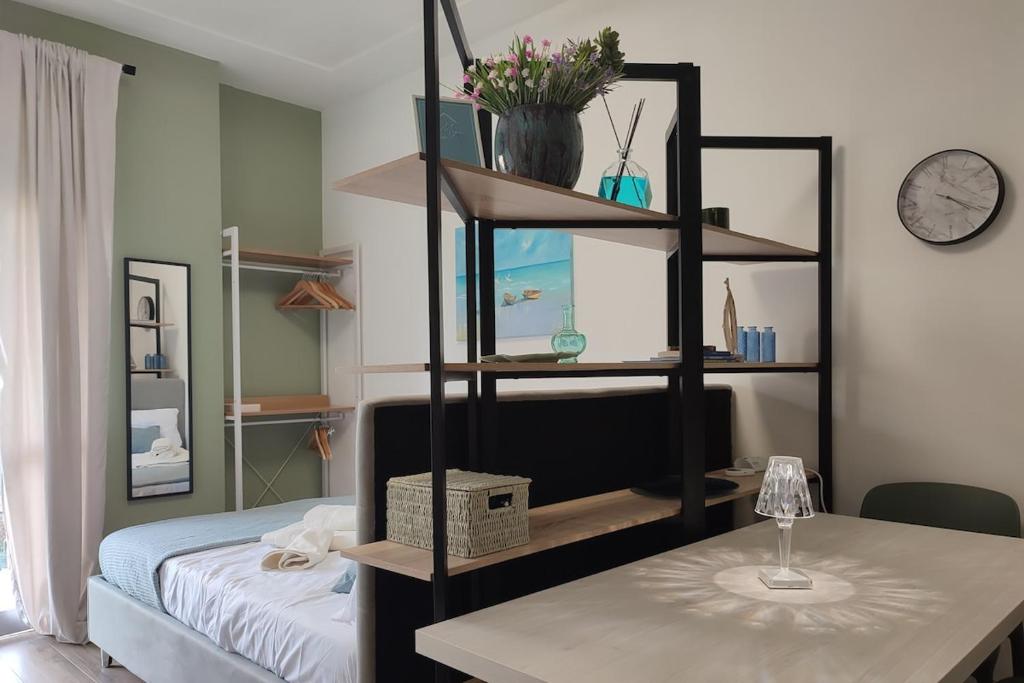 ein Zimmer mit einem Bett und einem Regal mit einem Tisch in der Unterkunft Magic Home in Ceriale