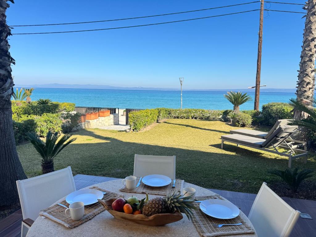 una mesa con un bol de fruta y vistas al océano en Exceptional beachfront villa Blue Pearl, en Pefkohori