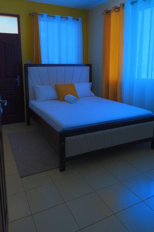 a bed in a room with a blue bedvisor at Delta shop house in Mombasa