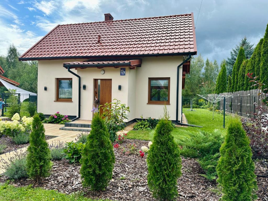 a small house with a garden in front of it at Dom całoroczny Trzyakacje in Rydzewo