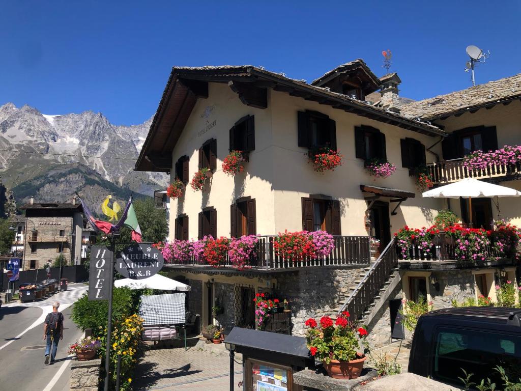 a building with flowers on the balconies on a street at Maison Laurent in Courmayeur