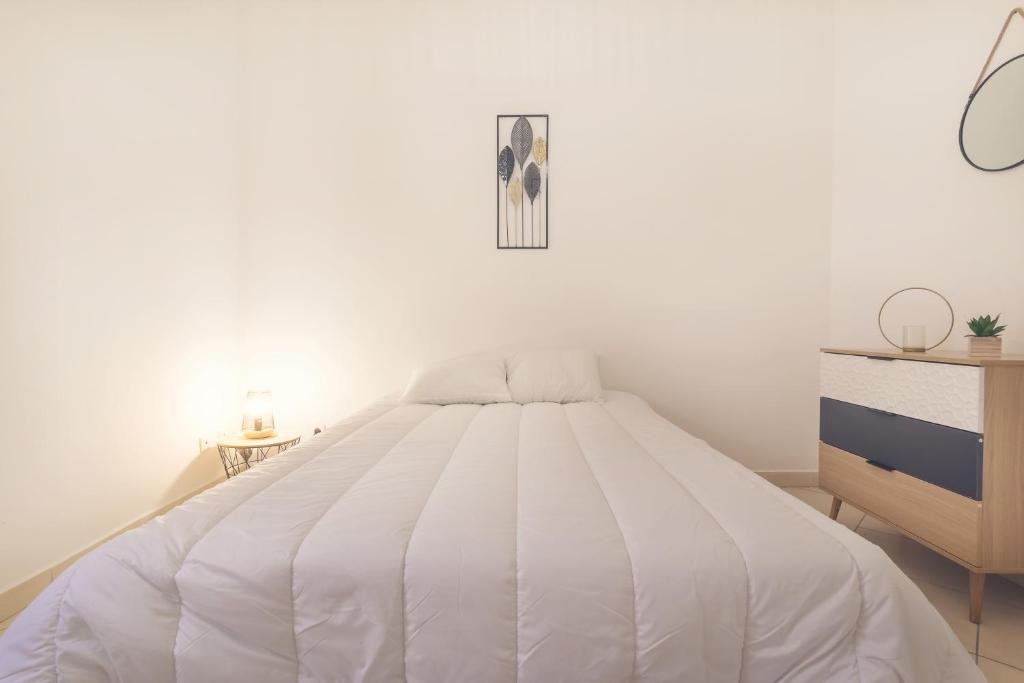 - une chambre blanche avec un lit blanc et une commode dans l'établissement Appartement tout équipé 4 à 6 couchages au cœur de Beziers, à Béziers