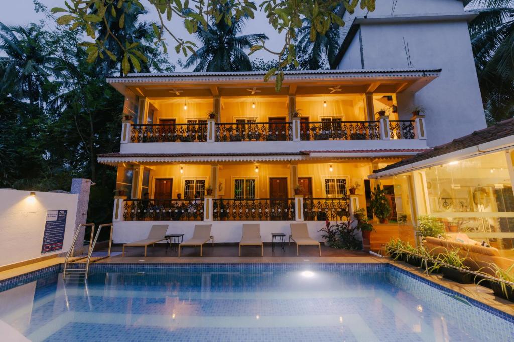 a hotel with a swimming pool in front of a building at Pvt Pool - Villa Azura Escape - Casa Marialina 8 BR in Saligao
