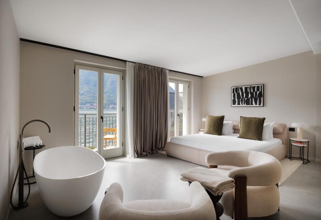 a bedroom with a large bed and a bath tub in a room at Maison MUSA at Ca' Bela in Sala Comacina