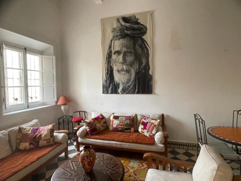 a living room with a couch and a painting on the wall at Appartement Riad Sidi Magdoul in Essaouira