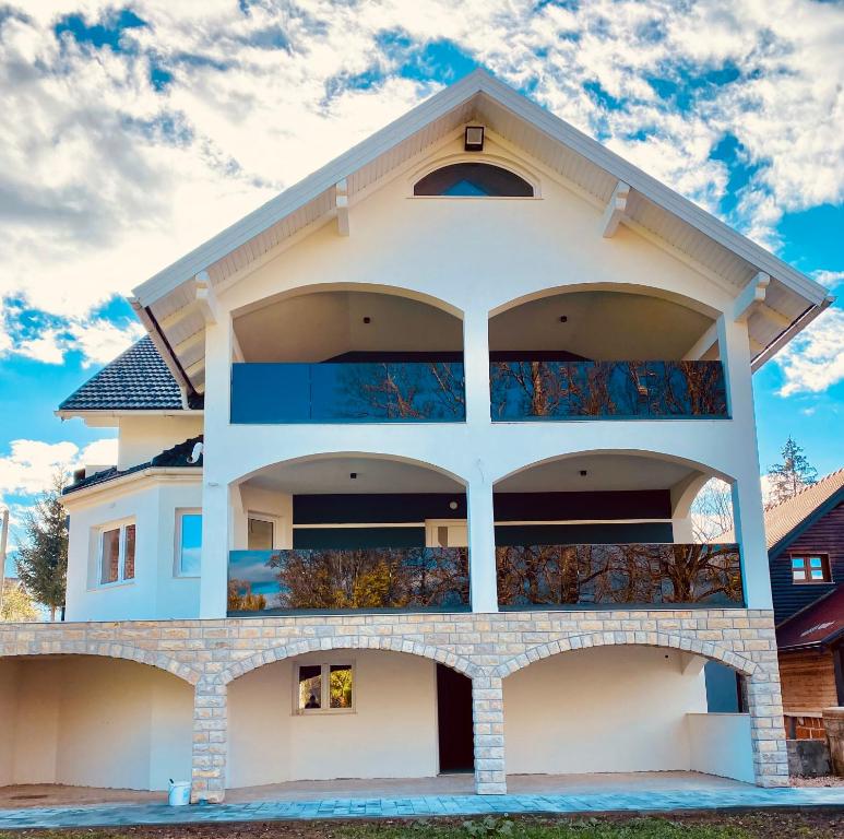 a white building with balconies on it at Filuma Suite with private terrace and balcony PANORAMIC GACKA VIEW in Otočac