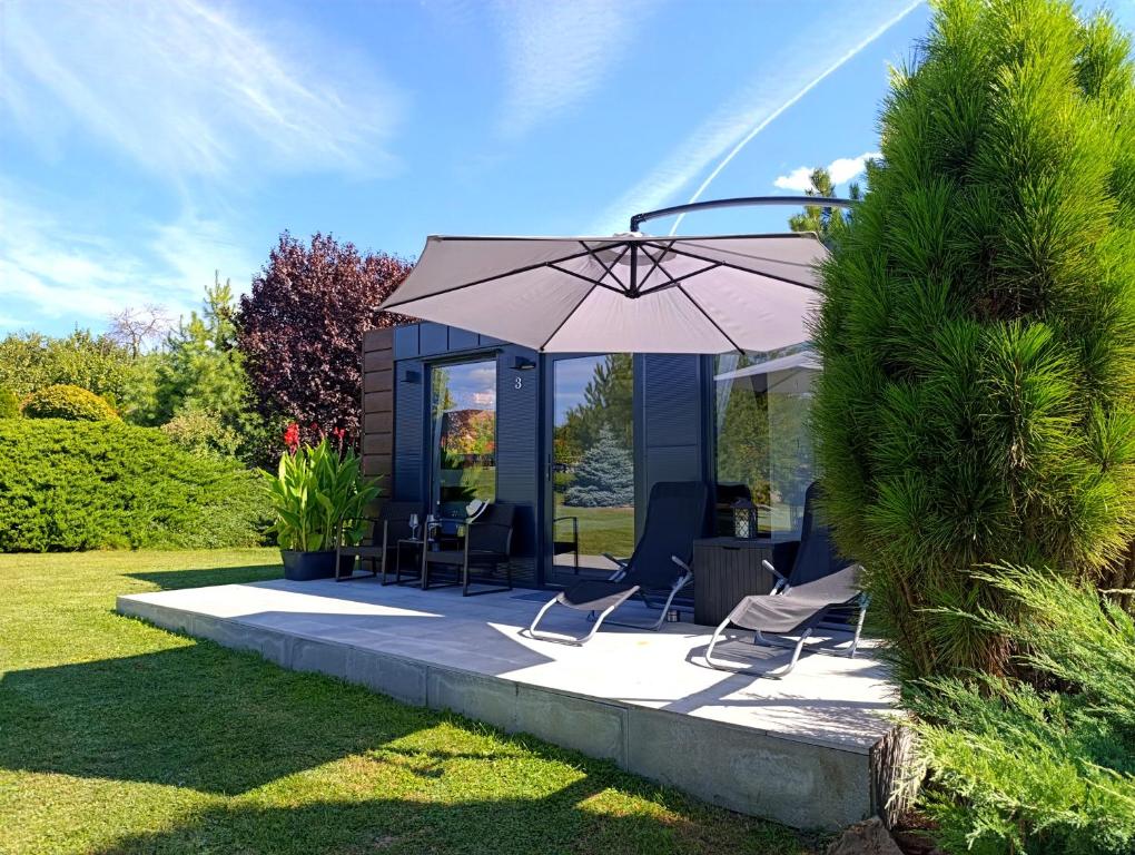 a patio with two chairs and an umbrella at TINY HOUSE mezi sklepy in Kobylí
