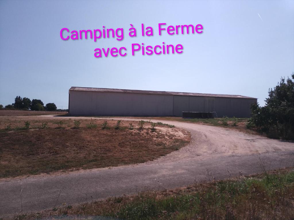 una strada sterrata accanto a un edificio con la scritta "campeggio alla fama piuttosto che al prestigio" di Camping les Petites Roches a Corme-Royal