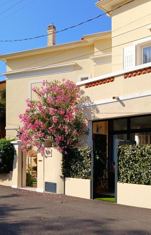 a building with a pink flowering tree in front of it at Studio port santa lucia in Saint-Raphaël