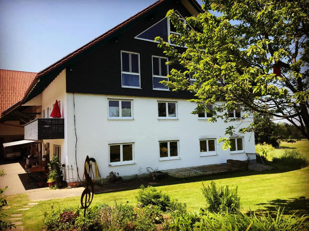 a large white house with a black roof at Landhof Nägele's vom Berg in Argenbühl
