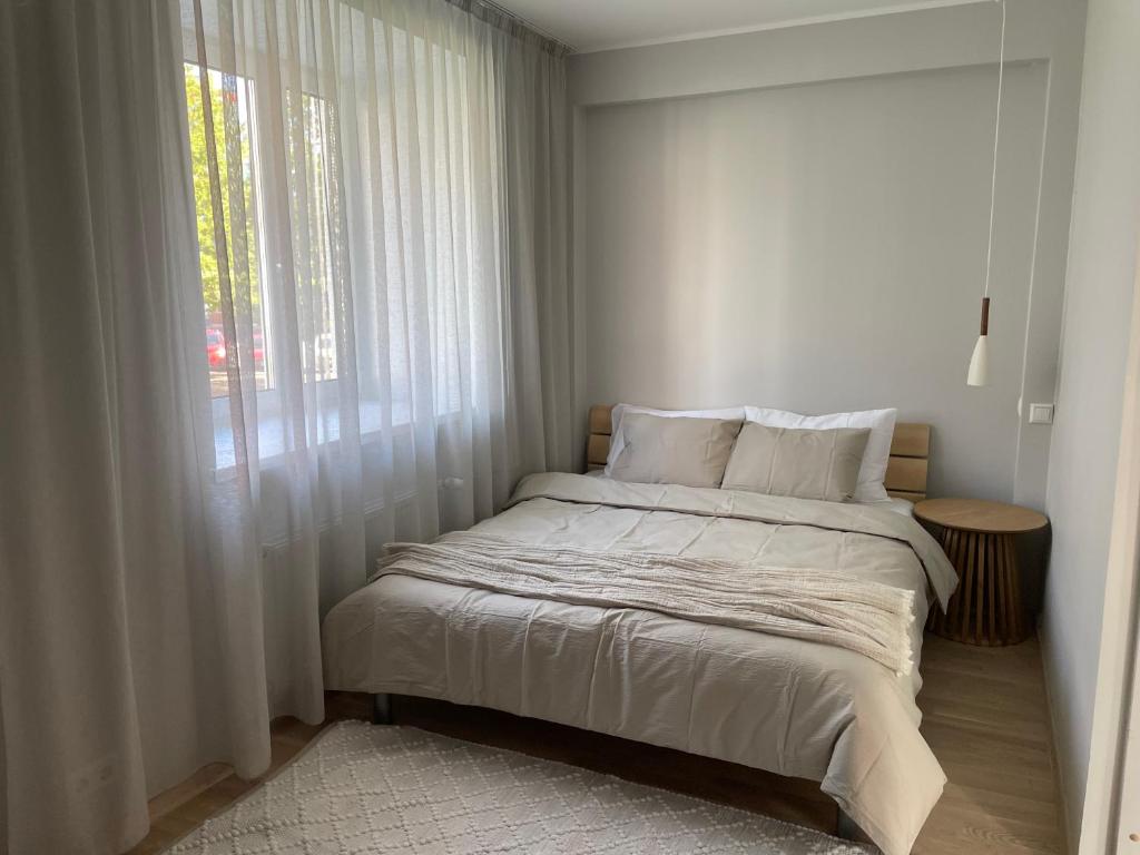 a bed in a white room with a window at Pikk 10 City Apartment, free parking in Pärnu