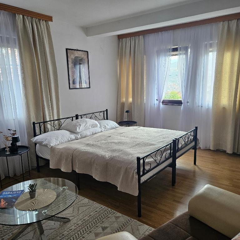 a bedroom with a bed and a living room at AC House Apartments in Sarajevo