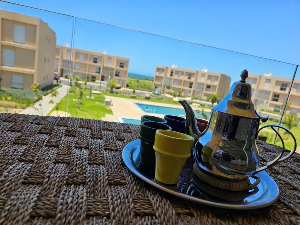 Authentic Taghazout في تغازوت: صحن مع غلاية الشاي وأكواب على طاولة