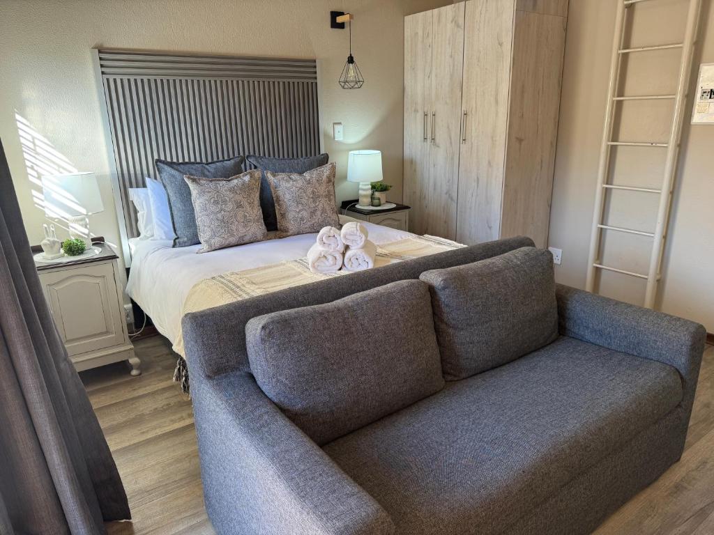 a bedroom with a bed and a couch at The Clarens Getaway in Clarens