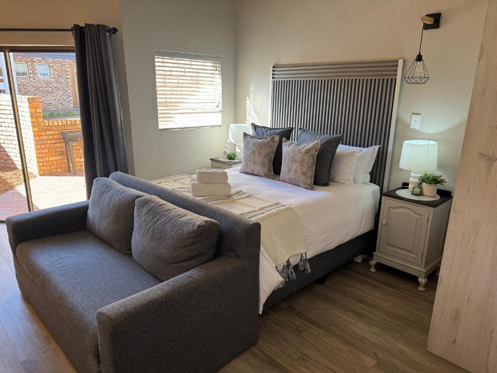a bedroom with a bed and a couch at The Clarens Getaway in Clarens