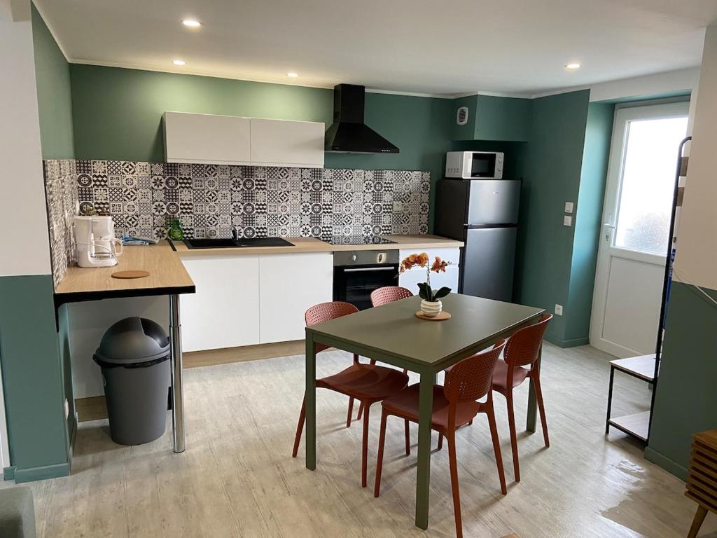 a kitchen with a table and chairs in a room at Joli appartement au calme in Bruay-la-Buissiere