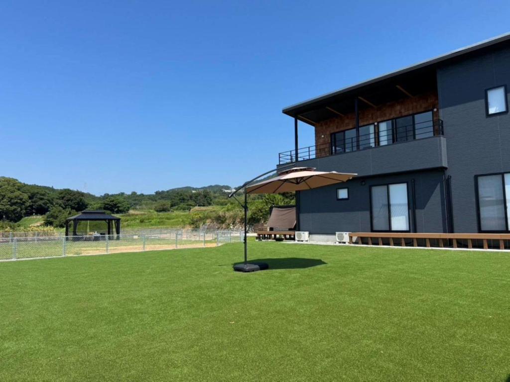 a building with an umbrella in a field of grass at Awaji - House - Vacation STAY 19734 in Awaji