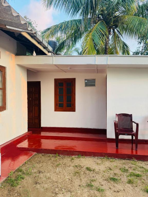 a chair sitting on the front of a house at Una Star Guest House in Trincomalee