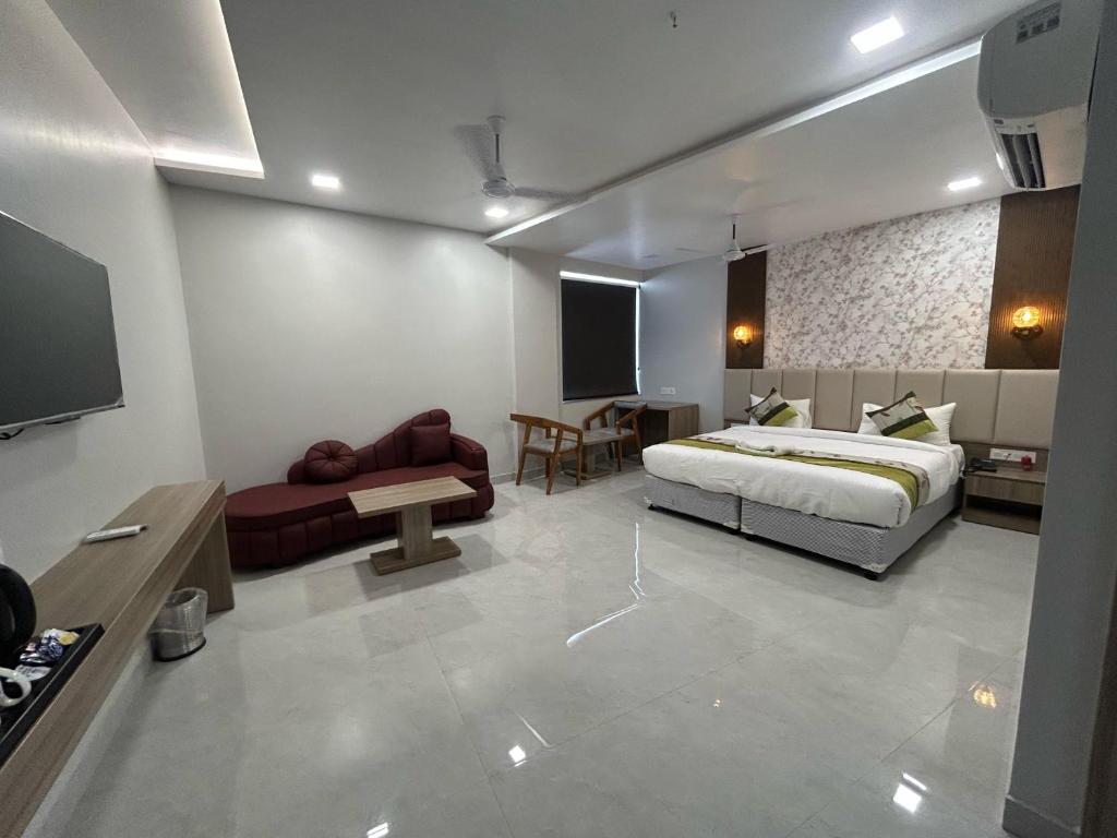 a bedroom with a bed and a living room at Kamala Inn Grand in Padrauna