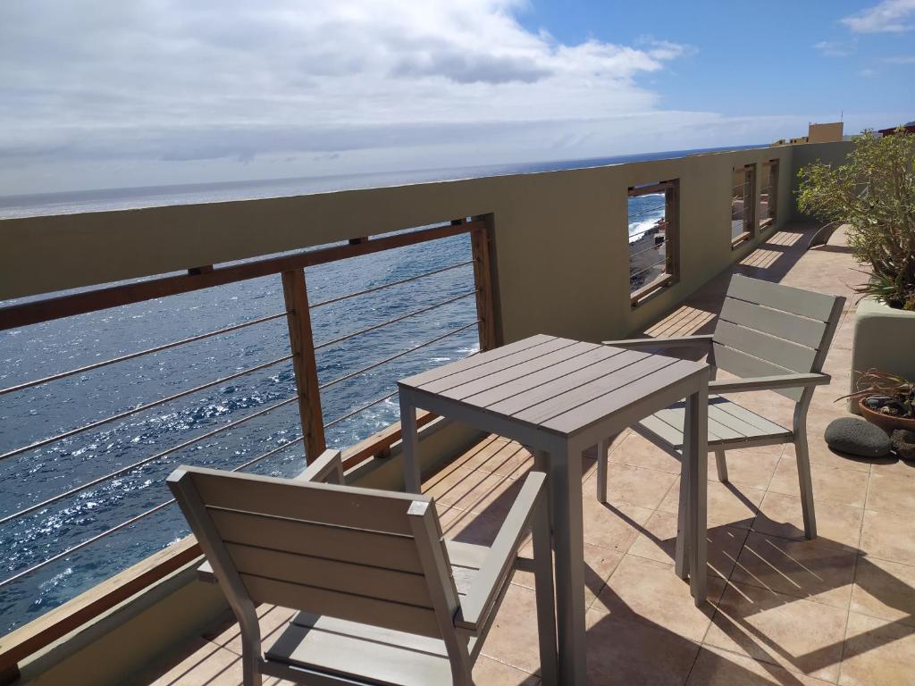 a balcony with a table and chairs and the ocean at Ático encima del mar in Santa Cruz de la Palma