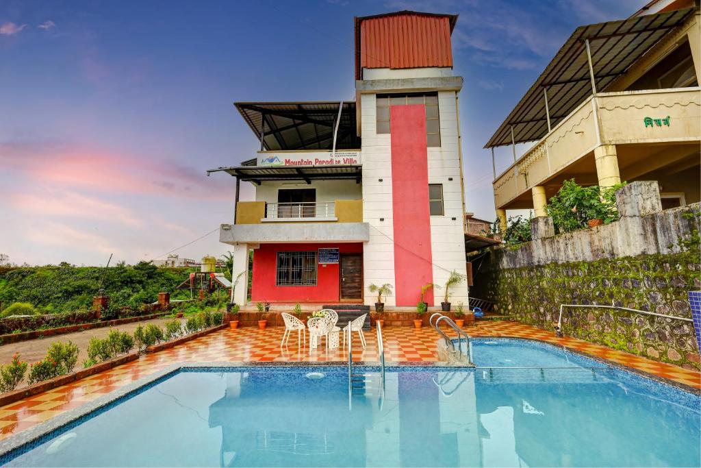 a pool in front of a building with a tower at Mountain Paradise Villa in Jāmb