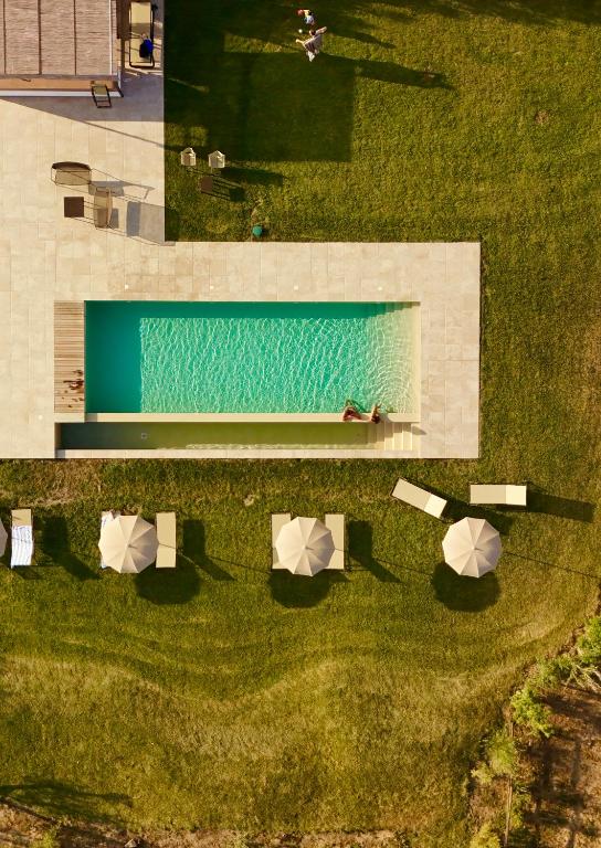 an overhead view of a pool with umbrellas in the grass at Casale Oliveta & Ristorante in Orbetello