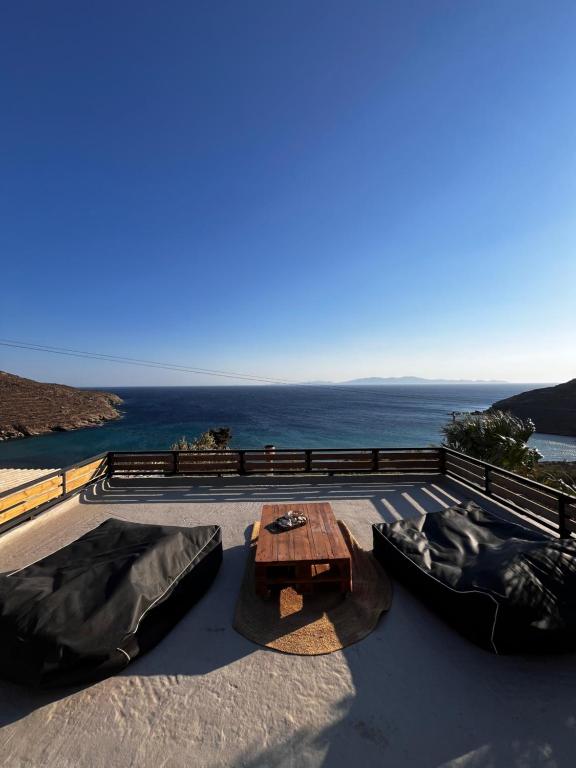 un tavolo e sedie su un tetto con l'oceano di La Casa Di Maryolo Zannel seaside serenity a Kardhianí