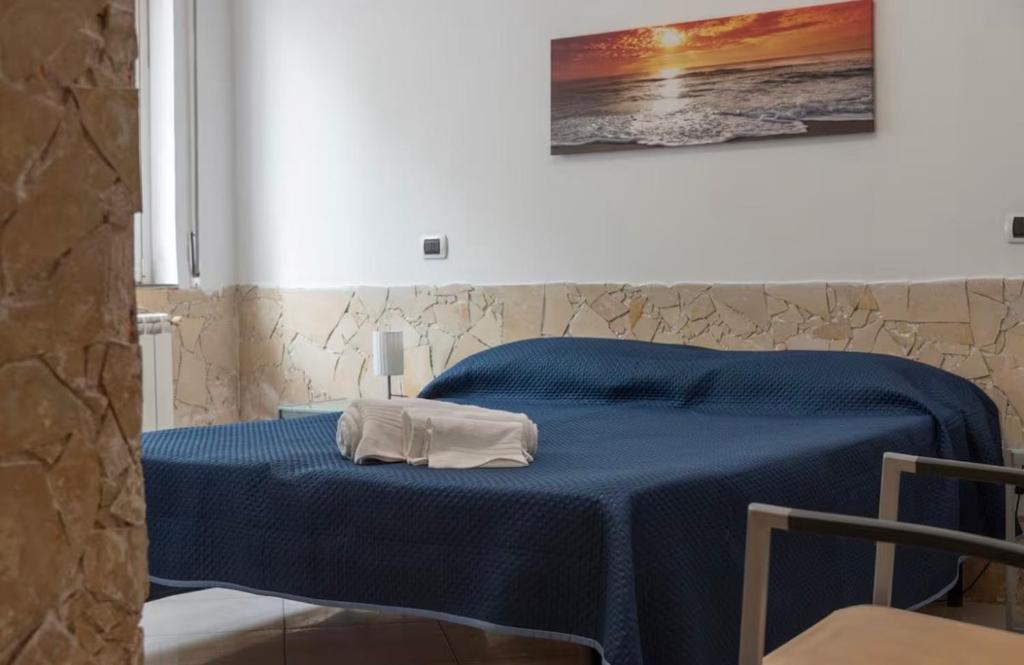 een blauw bed met een handdoek erop bij Terrace Garden Apartment in Acitrezza