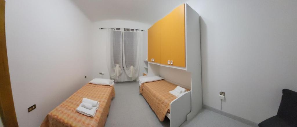 a small room with two beds and a mirror at Casa Valeria in Sulmona