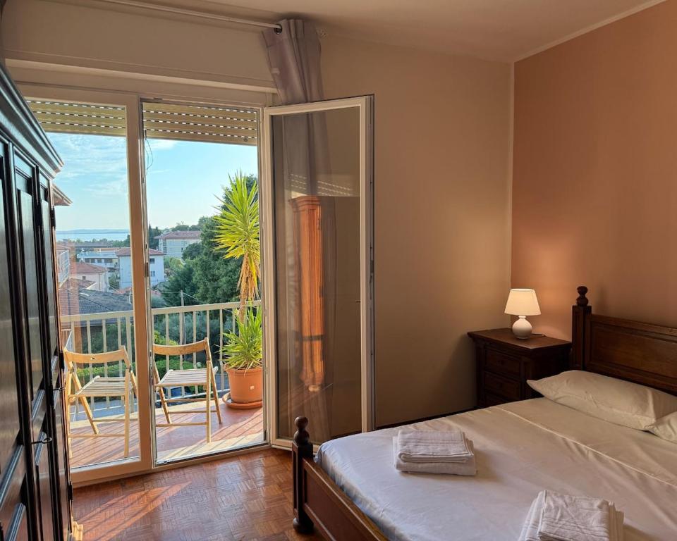 a bedroom with a bed and a view of a balcony at Bella vista - Garda Lake in Bardolino