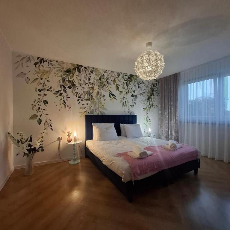 a bedroom with a large bed with a chandelier at Apartamenty TUTERRA I in Zabagnie