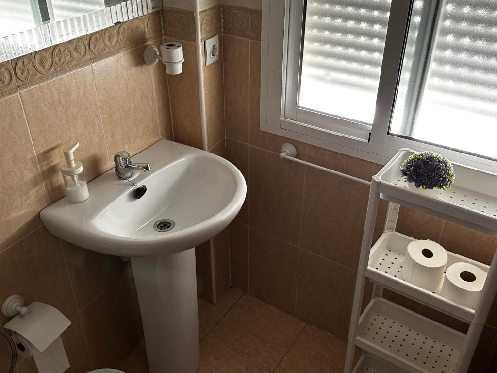 a bathroom with a white sink and a window at Sevilla. Gerena Casa Rural para familia o profesionales in Gerena