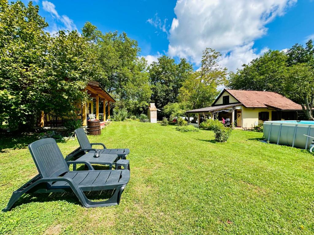 einen Stuhl auf dem Rasen im Hof in der Unterkunft Apartments Celopek in Ličko Petrovo Selo