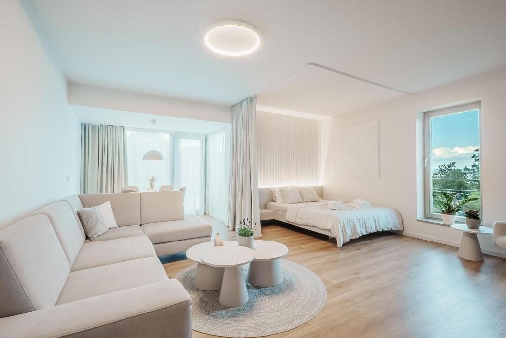 a white living room with a couch and a bed at Apartmán Milujto, Pálava in Pavlov