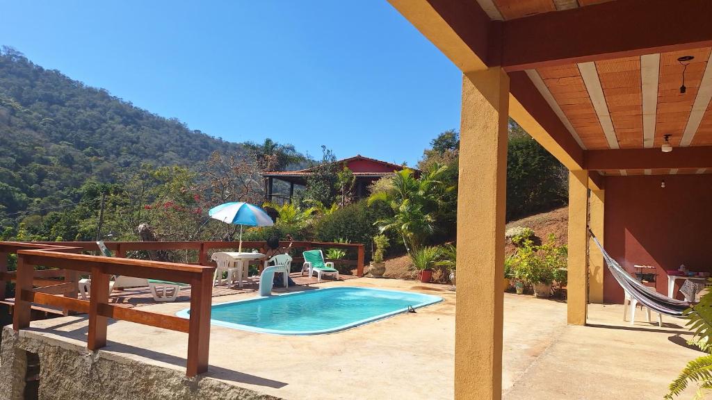 a house with a swimming pool and a patio at casa de campo bem na natureza in Araras Petropolis
