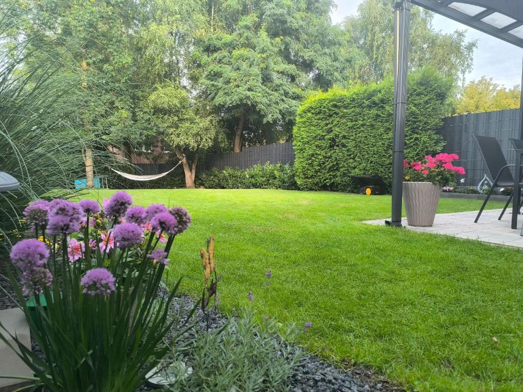 a garden with purple flowers and a hammock at Ferienhaus-Heide in Bad Fallingbostel