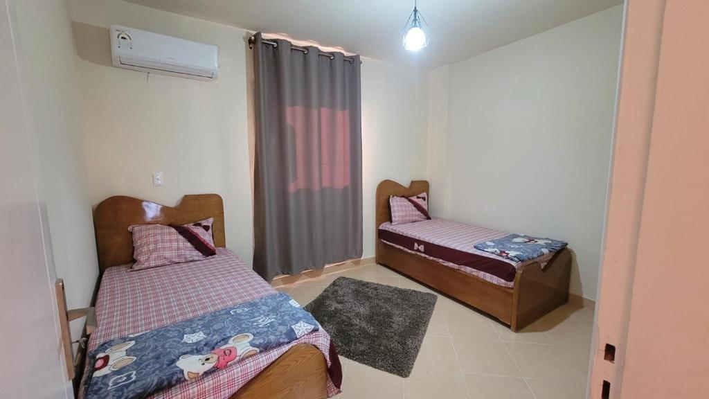 Un dormitorio con dos camas y una ventana. en لاسيرينا ريدكاربت, en Ain Sokhna