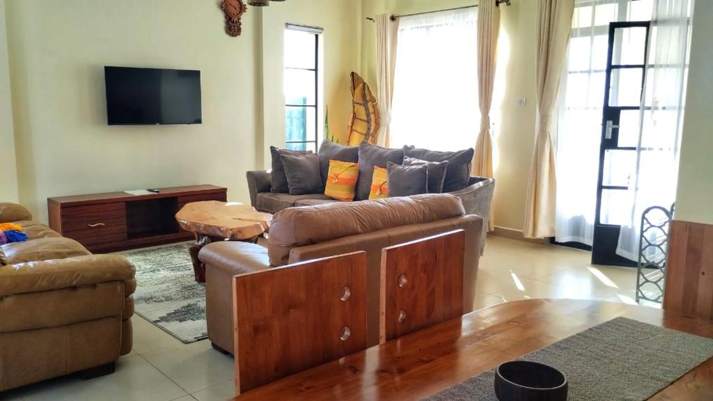 a living room with a couch and a table at Lamuria Naserian Villa in Nanyuki