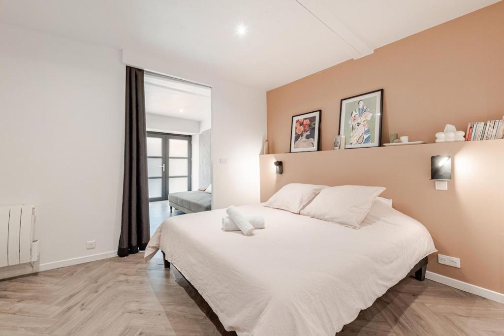 Un dormitorio con una cama grande con sábanas blancas. en La Petite Bégude Design & Spa, en La Bégude-de-Mazenc