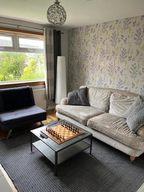 a living room with a couch and a chessboard at 3 bed self contained part house in Queensferry, Edinburgh in Queensferry