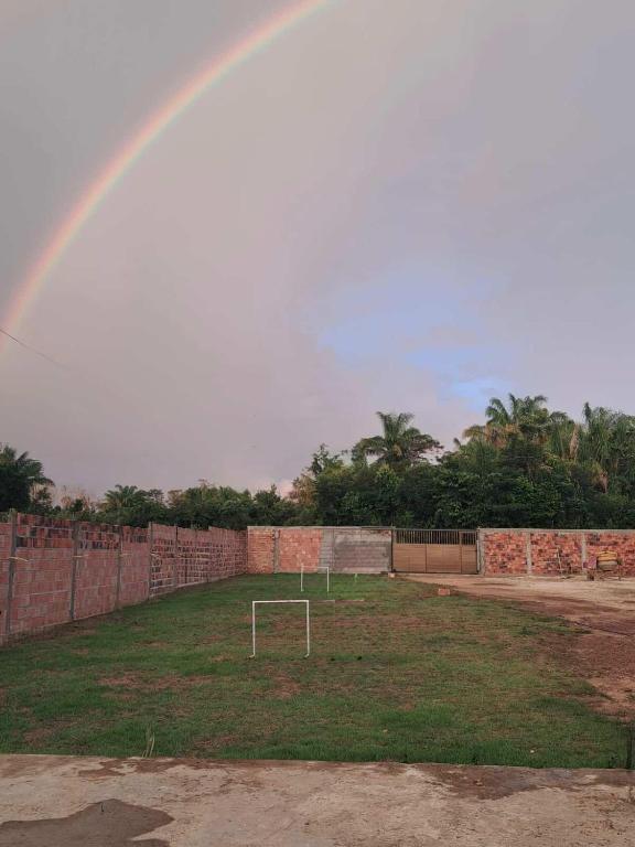 a rainbow over a field with a goal at Chácara Baruk in Iranduba