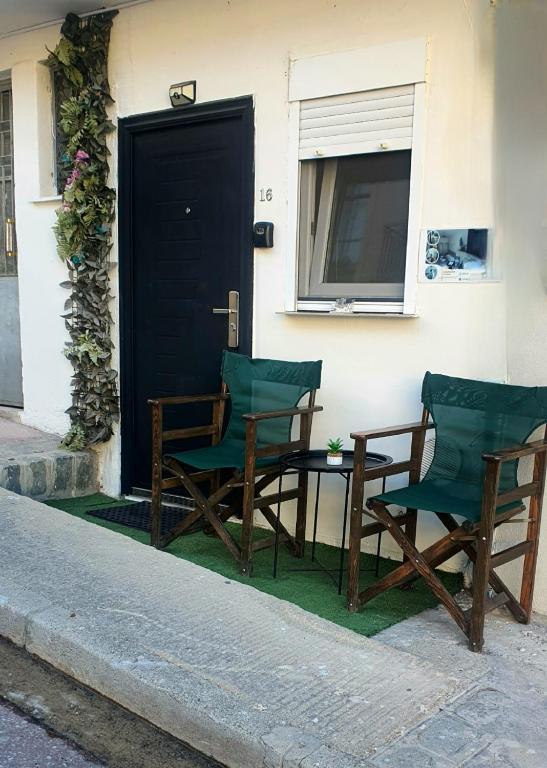 two chairs and a table in front of a door at St.Barbara studio in Drama