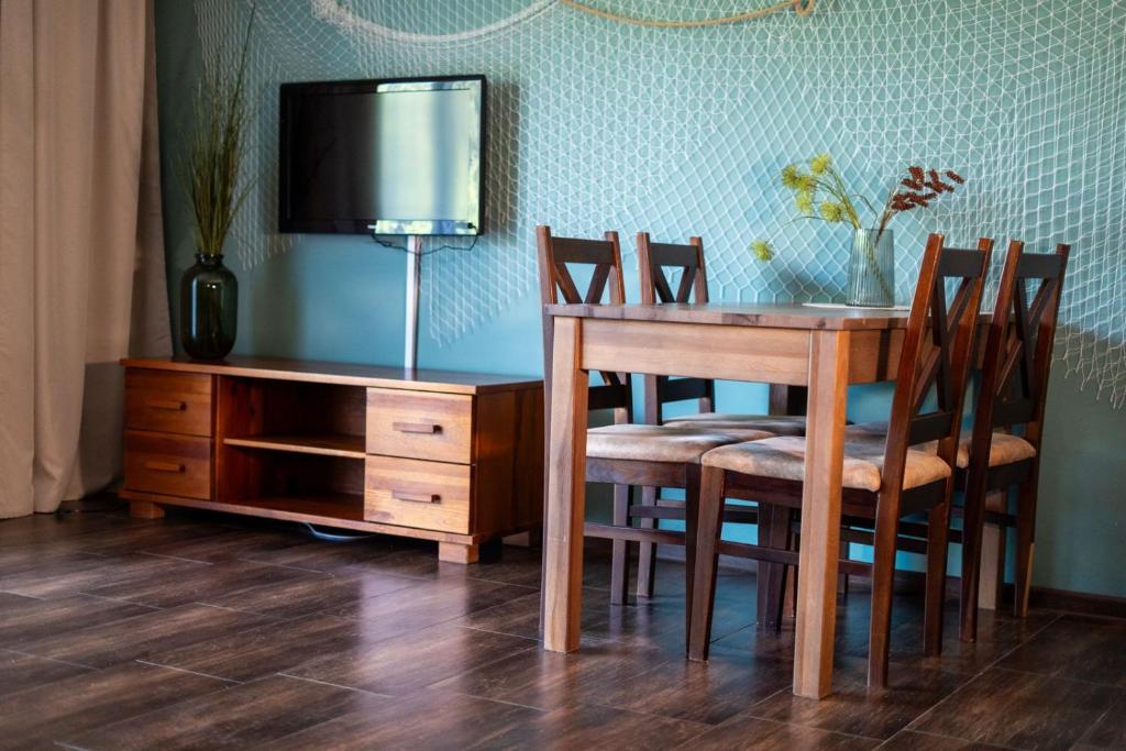 a dining room with a table and chairs and a tv at PANORAMA Małe Swornegacie in Małe Swornegacie