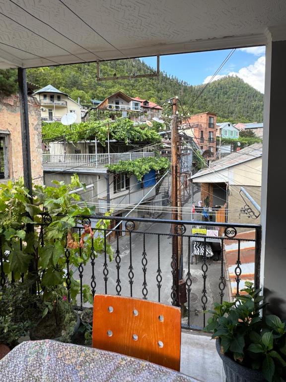 einem orangenen Stuhl auf dem Balkon in der Unterkunft Erik Guest House in Bordschomi