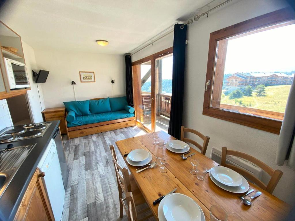 a kitchen and dining room with a table and a couch at Les Chalets De Superd Bleuet - 2 Pièces pour 6 Personnes MAE-8844 in Le Dévoluy