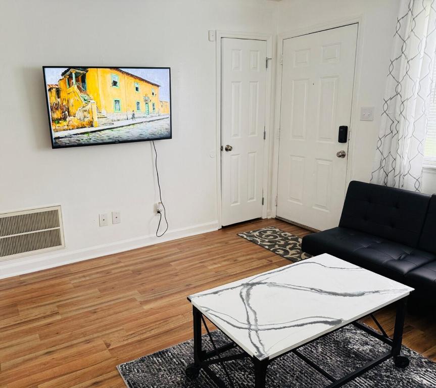 ein Wohnzimmer mit einer schwarzen Couch und einem Tisch in der Unterkunft DukeHaven near Northlake, Uptown, Route to Airport in Charlotte