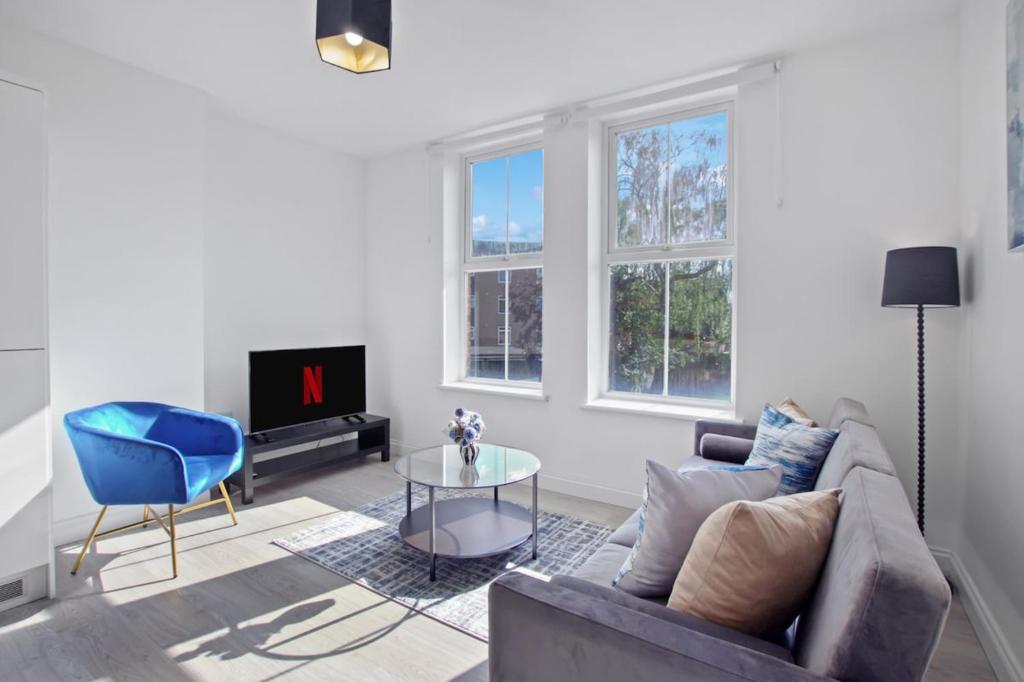 a living room with a couch and a tv at Modern Apartment, Free Parking, Smart TV, Sofa Bed in Bedford