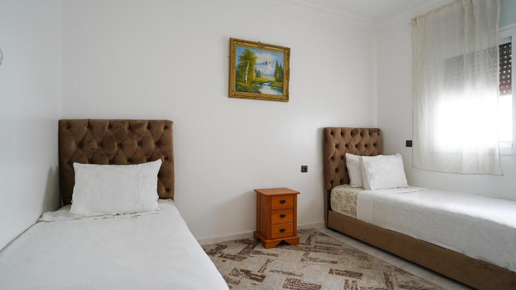 1 Schlafzimmer mit 2 Betten und einem Nachttisch in der Unterkunft Vacances sans effort au centre de la ville in Tangier