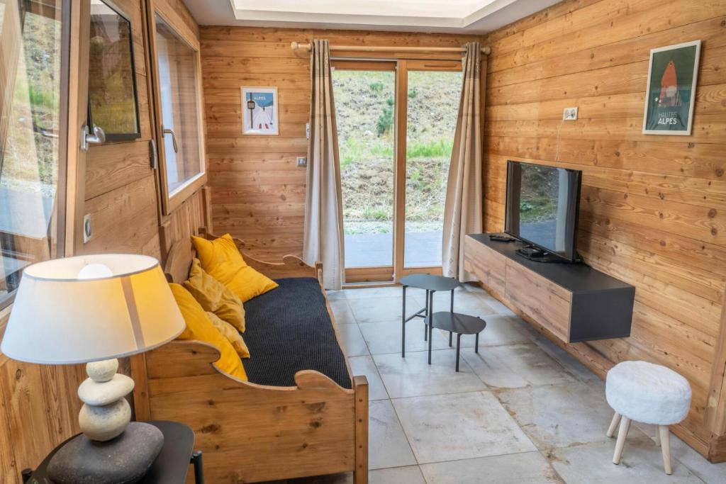 a living room with a couch and a television at Résidence Pramouton - Charmant logement au cœur d’un chalet de montagne MAE-3601 in Le Mélézet
