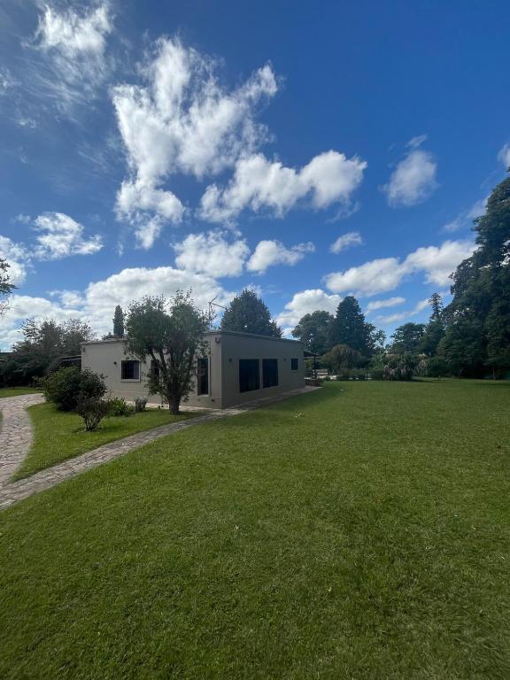 a house with a large field in front of it at Alma Quinta Maschwitz muy cerca de Temaiken in Maquinista Savio
